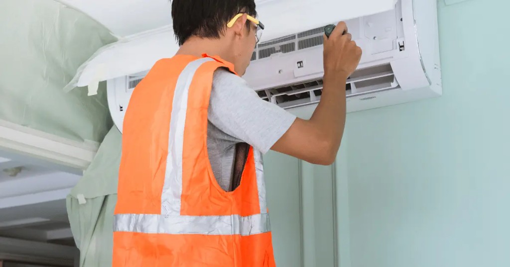 Tecnico profissional realizando instalacao de ar condicionado split com EPI e boas praticas de seguranca